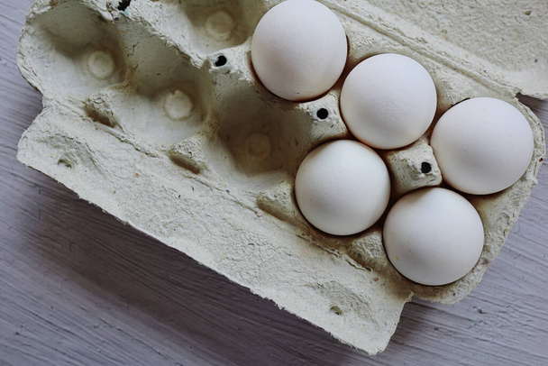 eggs on the wooden board.cardboard box with eggs.white chicken egg.home farm.ingredients.cooking in the kitchen.lots of eggs.cooking as a hobby.selling eggs.packaged eggs.shell.organic food.quality product.proper nutrition.egg packaging. shop  - Zdjęcie, obraz