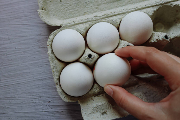 chicken eggs in the nest.chicken egg in hand.cardboard box with eggs.white chicken egg.home farm.ingredients.cooking in the kitchen.lots of eggs.cooking as a hobby.selling eggs.packaged eggs.shell.organic food.cooking. - Zdjęcie, obraz