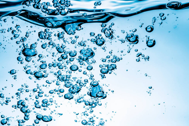 Modrá voda stříká. Šplouchání vody bublinou. Zavřete vodu. Čerstvá modrá přírodní pitná voda. - Fotografie, Obrázek