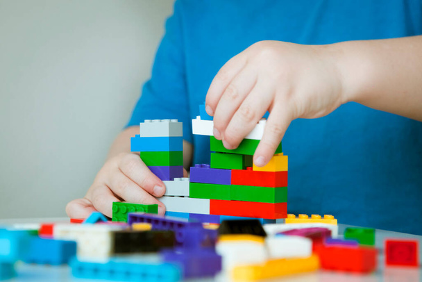 Boy plays colorful multi-colored cubes and cars on the table. Early development and learning. . High quality photo - Photo, image