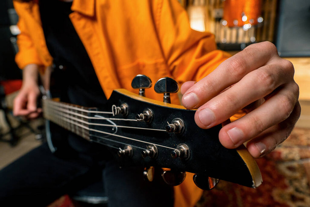 rock előadó elektromos gitárral stúdió felvétel lejátszása saját pálya hangolás hangszer húrok closeup - Fotó, kép