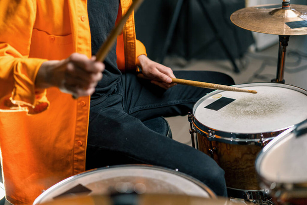 mladý bubeník hraje na bicí soupravu v nahrávacím studiu na profesionální muzikantskou nahrávací píseň - Fotografie, Obrázek