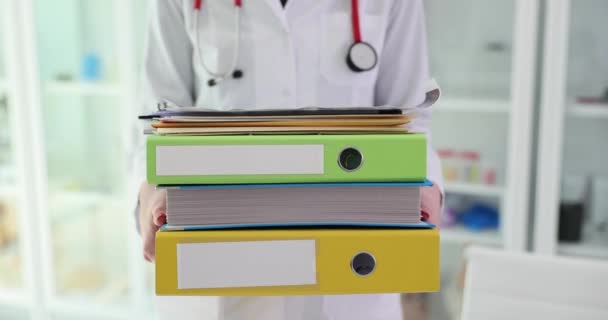 Arzt hält großen Stapel von Ordnern und medizinischen Dokumenten. Medizingeschichte und medizinische Ausbildung und Ausbildung - Filmmaterial, Video