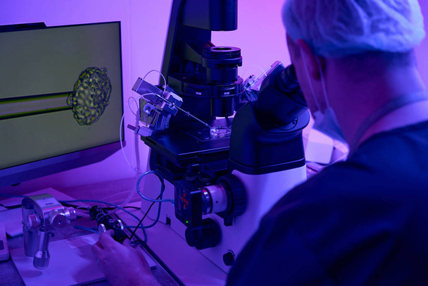 Professional embryologist carefully working with micromanipulator, embryo cultivation or fertilization, biopsy of cells, researches - Photo, image