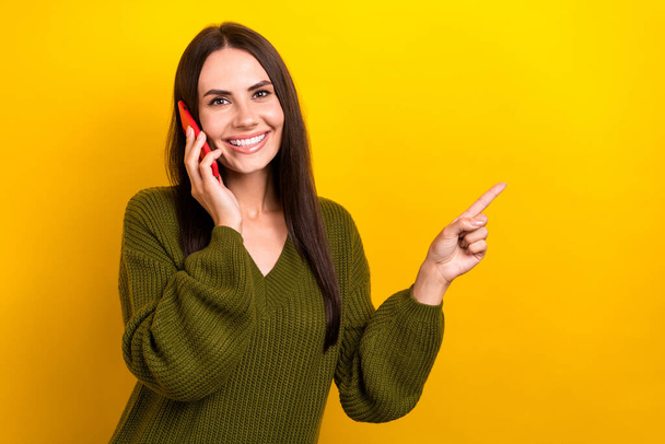 Photo of sweet pretty lady wear khaki pullover talking apple samsung apple gadget showing empty space isolated yellow color background. - Foto, Imagen