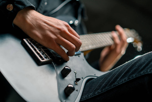 rock performer με ηλεκτρική κιθάρα σε ηχογράφηση στούντιο ηχογράφησης παίζει το δικό του κομμάτι δημιουργώντας τραγούδι έγχορδα μουσικό όργανο closeup - Φωτογραφία, εικόνα