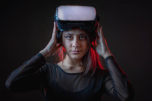Beautiful active young attractive caucasian fit model woman uses hi tech futuristic Vr glassess for augmented reality. Photo of sportive beauty brunette sportswoman attractive white model. - Photo, Image