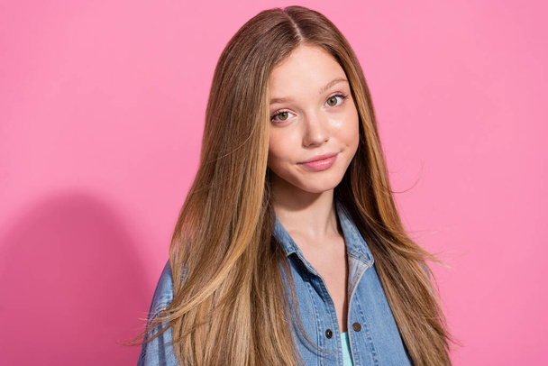 Portrait of lovely cute girl dressed denim clothes demonstrating haircare beauty products isolated on pink color background. - Foto, imagen