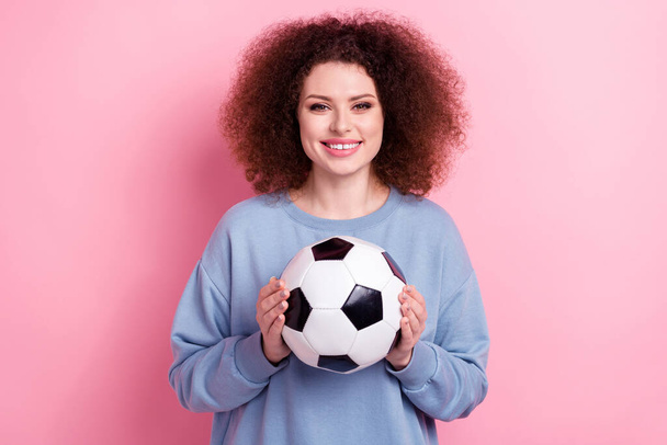 Photo of cheerful positive lady dressed blue pullover smiling holding football ball isolated pink color background. - Fotó, kép