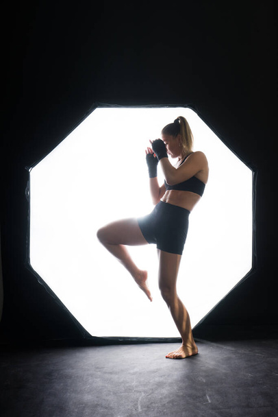 Woman Boxer In Gloves Training On a black, red, yellow Background - Fotoğraf, Görsel