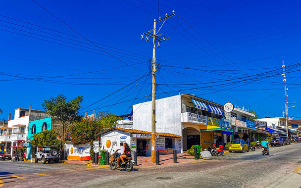 Puerto Escondido Oaxaca Mexico 16. January 2023 Typical beautiful colorful tourist street road and sidewalk with city life cars traffic buildings hotels bars restaurants and people in Zicatela Mexico. - Fotografie, Obrázek