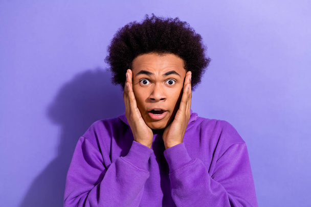 Portrait of impressed speechless man arms touch cheekbones open mouth cant believe isolated on purple color background. - Foto, Imagen
