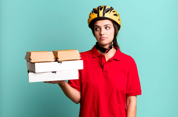 young pretty woman on profile view thinking, imagining or daydreaming. pizza delivery concept - Foto, afbeelding