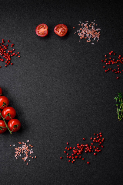 Koyu beton zeminde domates, tuz, baharat ve otlar pişirmek için gerekli malzemeler. - Fotoğraf, Görsel