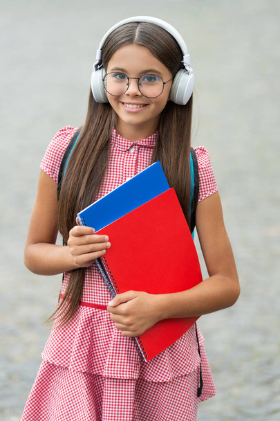 teen girl has estudy in headphones hold notebook. teen girl has estudy outdoor. photo of teen girl has estudy during holidays. teen girl has estudy. - Valokuva, kuva