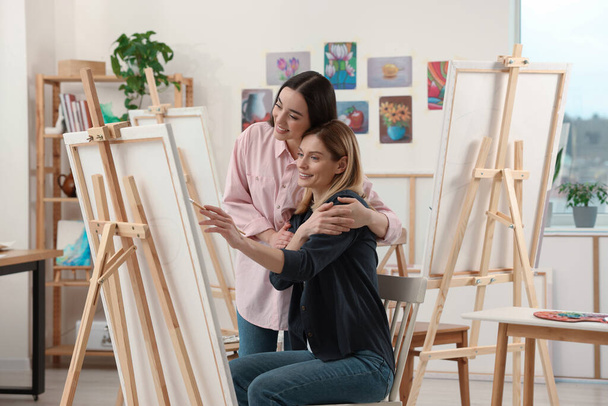 Artist teaching her student to paint in studio. Creative hobby - Foto, Bild