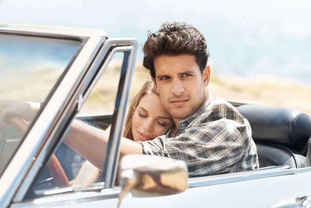 Enjoying the sun and fresh air. an attractive young couple traveling in a convertible - Фото, изображение