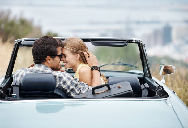 Enjoying an afternoon at the lookout...An attractive young couple in their convertible while on a roadtrip - 写真・画像