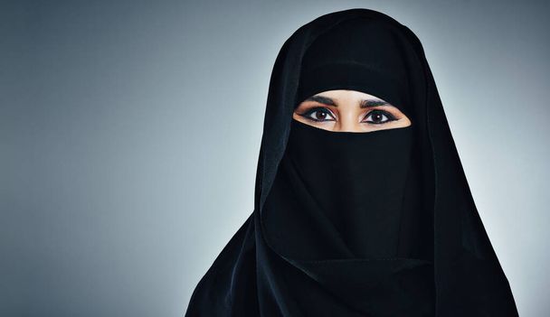 Bescheidenheid is altijd mooi. Studio portret van een jonge moslim zakenvrouw tegen een grijze achtergrond - Foto, afbeelding