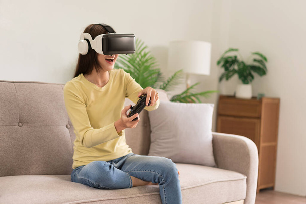Vapaa-ajan toiminta konsepti, nuori nainen pelaa jännittävää peliä VR-laseilla ja ohjaussauvalla. - Valokuva, kuva