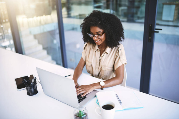 Poner manos a la obra en el éxito empresarial. una joven empresaria que usa un portátil en su escritorio en una oficina moderna - Foto, Imagen