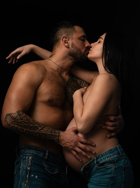 Kiss. Happy pregnant woman with her husband. Hands and torso of a pregnant woman and her husband. Expectant parents mom and dad waiting for their baby love concept - Zdjęcie, obraz
