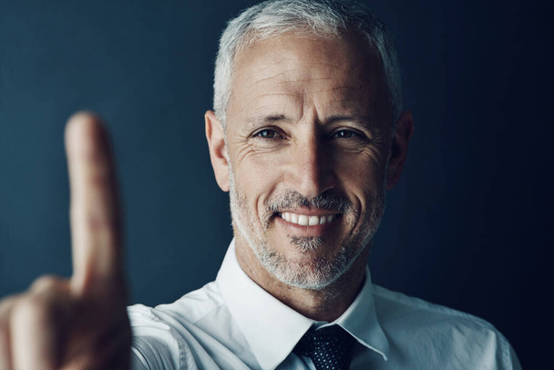 Liiketoiminta on helppoa. onnellinen liikemies, joka nostaa sormeaan ikään kuin toimistossa olisi kosketusnäyttö - Valokuva, kuva
