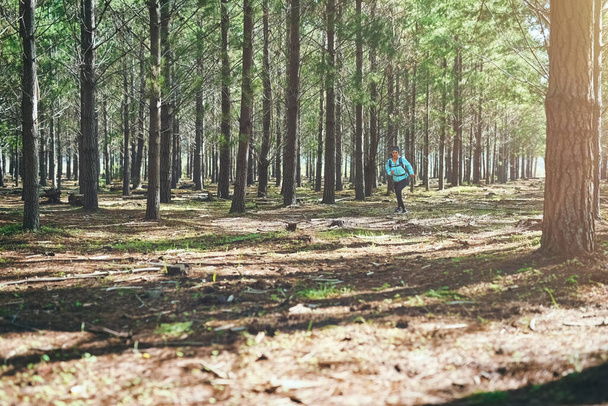 Fitness is a way of life. Full length shot of an athletic young woman out for a jog in the woods - Foto, Imagem
