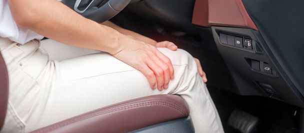 Frau mit Knieverstauchung während der langen Autofahrt, Patellofemorales Schmerzsyndrom, Arthrose, Arthritis, Rheuma und Patellarsehnenentzündung. medizinisches und ergonomisches Konzept - Foto, Bild