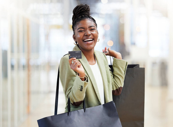 ショッピングバッグ付きの黒の女性、肖像画の笑顔とクレジットカードは、商業、支払いやショッピングモールで銀行。幸せなアフリカの女性の人や買い物客は銀行、購入または電子購入のためのデビット付き笑顔. - 写真・画像