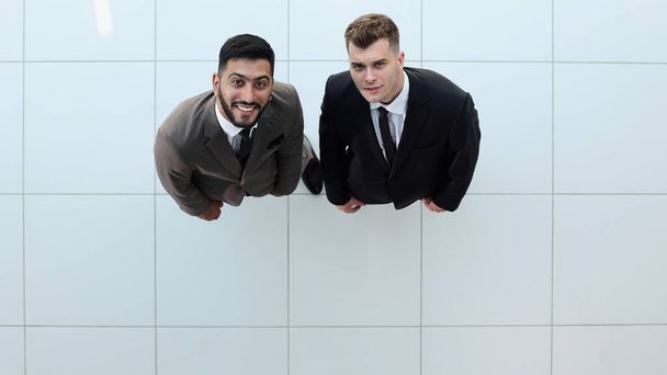 Retrato de dos socios de negocios concentrados vestidos con traje formal caminando y conversando durante la reunión de trabajo - Foto, imagen