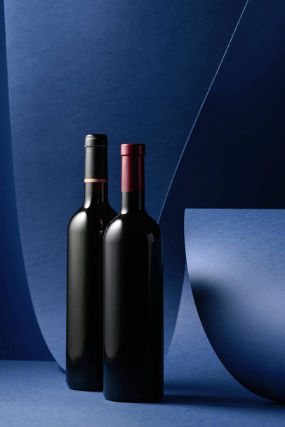 Flessen rode wijn op een blauwe achtergrond. Kopieerruimte. - Foto, afbeelding