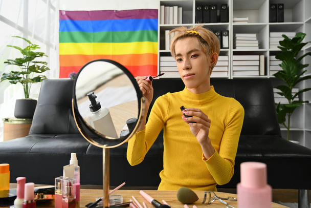 Hymyilevä aasialainen homo mies bloggaaja kuvaamisen päivittäin meikki rutiini opetusohjelma älypuhelimella. LGBTQ, kotielämän ja kauneuden käsite. - Valokuva, kuva