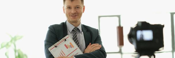 Male business coach standing in front of camera with documents in hands. School of business online concept - Foto, immagini
