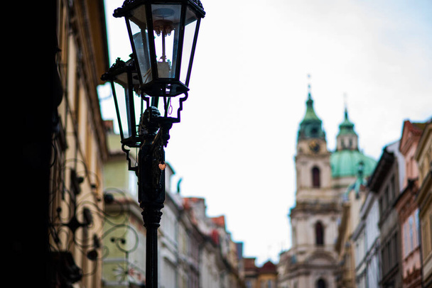 Head of an old fashioned victorian style lamp post against an old buildings. - Fotó, kép