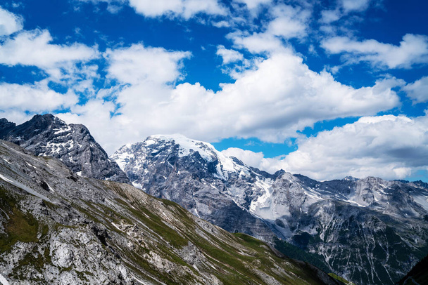Passing clouds over idyllic landscape in the Alps with snow-capped mountain tops in the background. Alpine mountains ridge landscape in the beauty of the French, Italian and Swiss Alps. - Fotó, kép