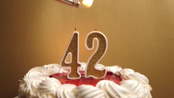 キャンドルは42番の形で灯され、休日のケーキに詰め込まれています。誕生日やランドマークイベントを祝う。お祝いのクライマックス. - 映像、動画