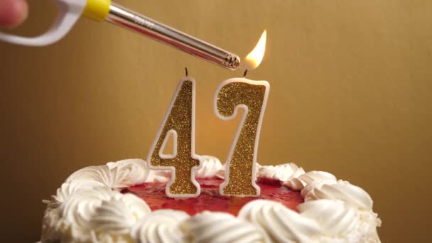 Una vela se enciende en la forma del número 47, que se pega en el pastel de vacaciones. Celebrar un cumpleaños o un evento histórico. El clímax de la celebración. - Metraje, vídeo