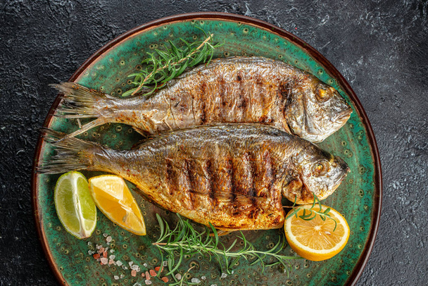 Baked Dorado Sea Bream fish on plate. Healthy food concept. place for text, top view. - Photo, Image