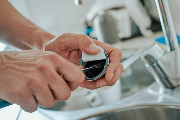 lähikuva valkoihoisesta miehestä keittiössä tyhjentämässä kapselin käytettyä jauhettua kahvia kapselin kierrättämiseksi - Valokuva, kuva