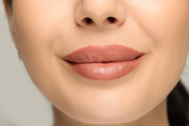 Woman with nude lipstick on light background, closeup - Foto, immagini