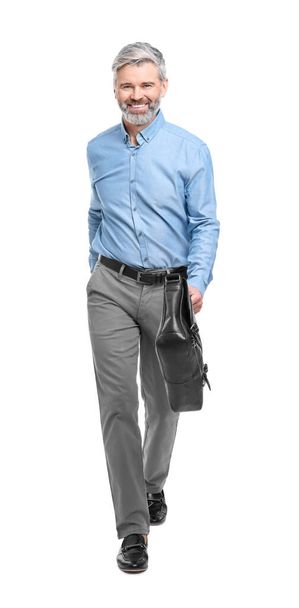 Mature businessman in stylish clothes with briefcase walking on white background - Zdjęcie, obraz
