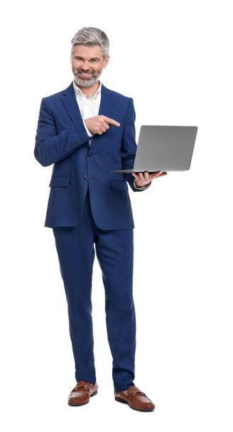 Mature businessman in stylish clothes with laptop on white background - 写真・画像