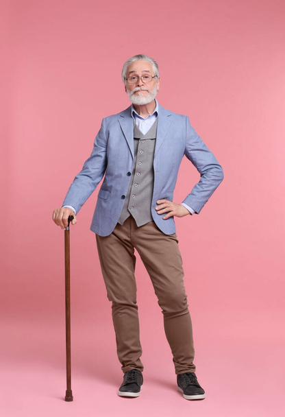 Senior man with walking cane on pink background - Fotoğraf, Görsel