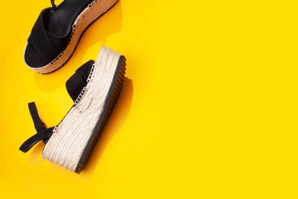Sandals espadrilles with straw soles on a yellow background. Flat lay style - Photo, Image