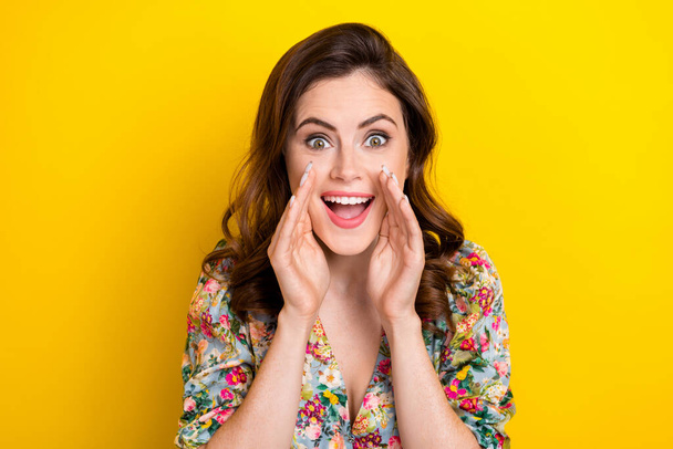 Photo of impressed excited woman dressed vintage flower print blouse arms mouth screaming isolated yellow color background. - Foto, immagini