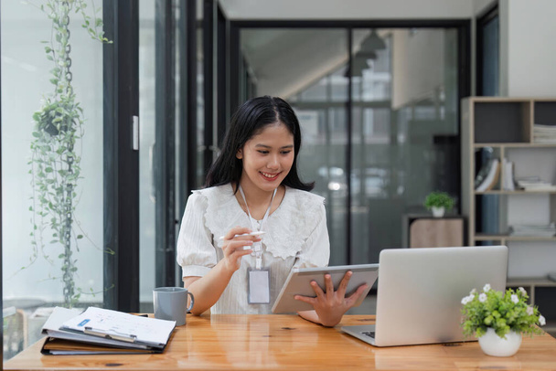 Asian Businesswoman Korzystanie z laptopa i tabletu pracy w biurze z dokumentem na biurku. - Zdjęcie, obraz