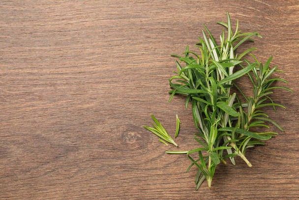 Fresh green rosemary on wooden table, top view. Space for text - Foto, immagini