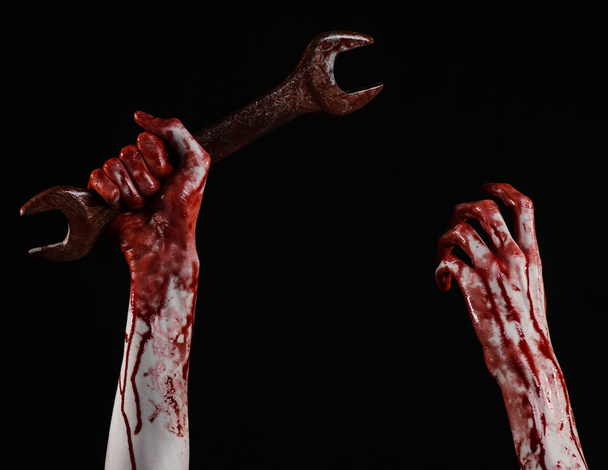 bloody hand holding a big wrench, bloody wrench, big key, bloody theme, halloween theme, crazy mechanic, murderer, psycho, violence, zombies, black background, isolated, revolution - Fotoğraf, Görsel