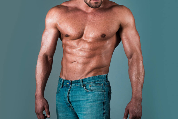 Mann mit sexy Körper. Muskulöser Oberkörper von sexy jungen männlichen Bodybuilder macht athletischen Mann mit perfekten Muskeln Bauch und nackte Brust auf grauem Hintergrund - Foto, Bild